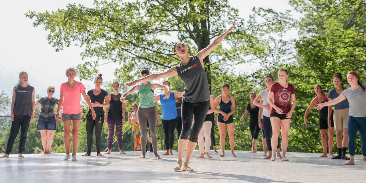 Artistic Director of Bruce Wood Dance leads a workshop for numerous participants on the outdoor stage.