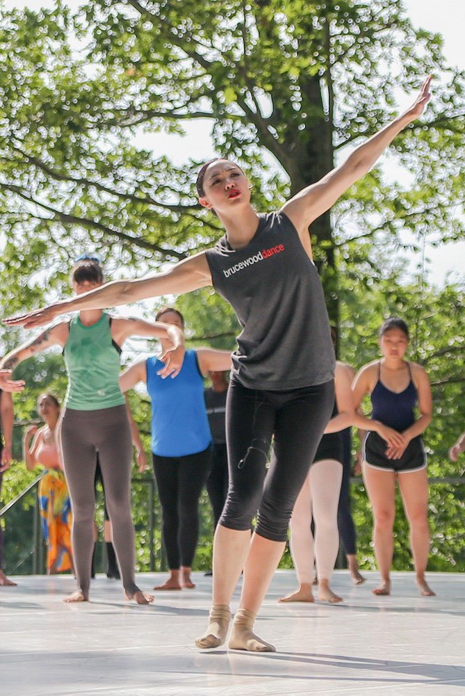 Artistic Director of Bruce Wood Dance leads a workshop for numerous participants on the outdoor stage.